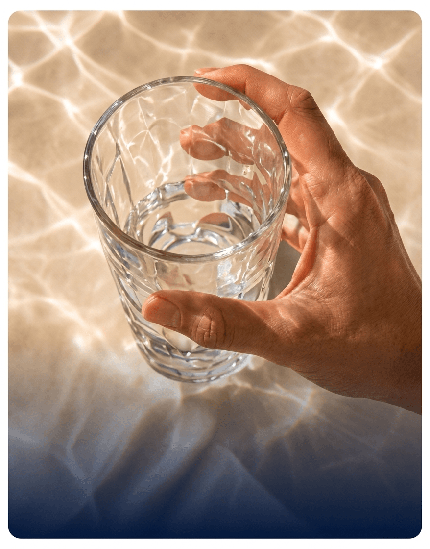 A hand holding a glass of water.